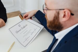 A man holding a divorce certificate in a formal office environment.